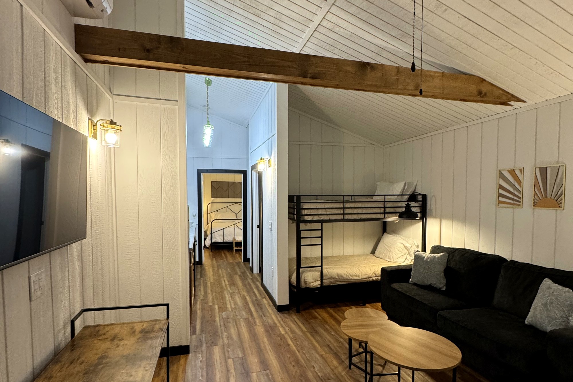 Park-model cabin living area with sofa, kitchenette and large windows at Haven Hills
