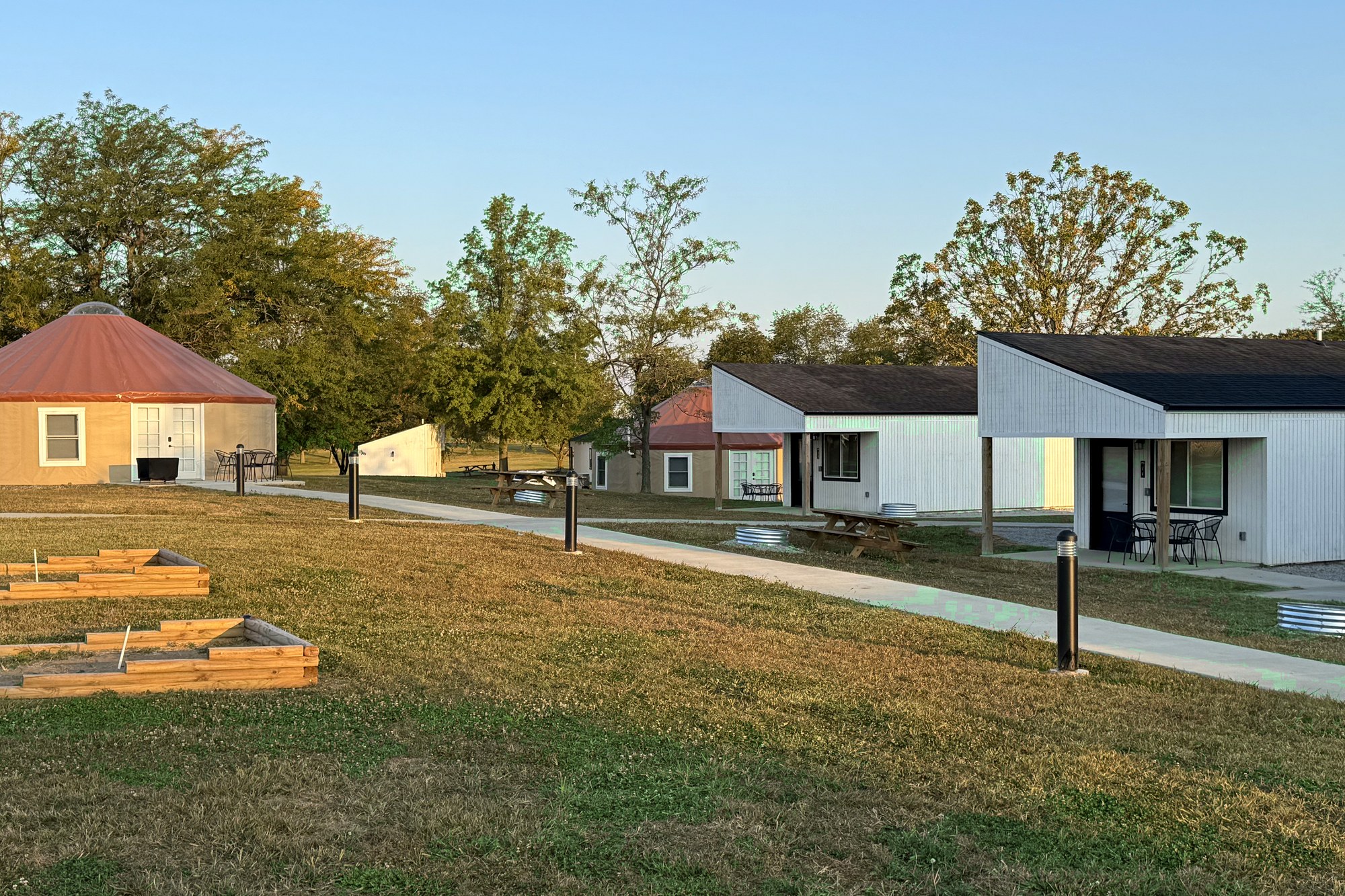 Row of park-model cabins and yurts on mowed lawn at Haven Hills Campground & Resort