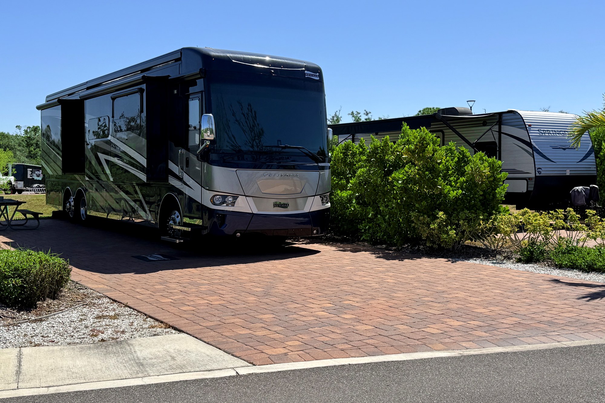 Paved premium RV site with patio, palms and utility pedestal at Keylime Bay RV Resort
